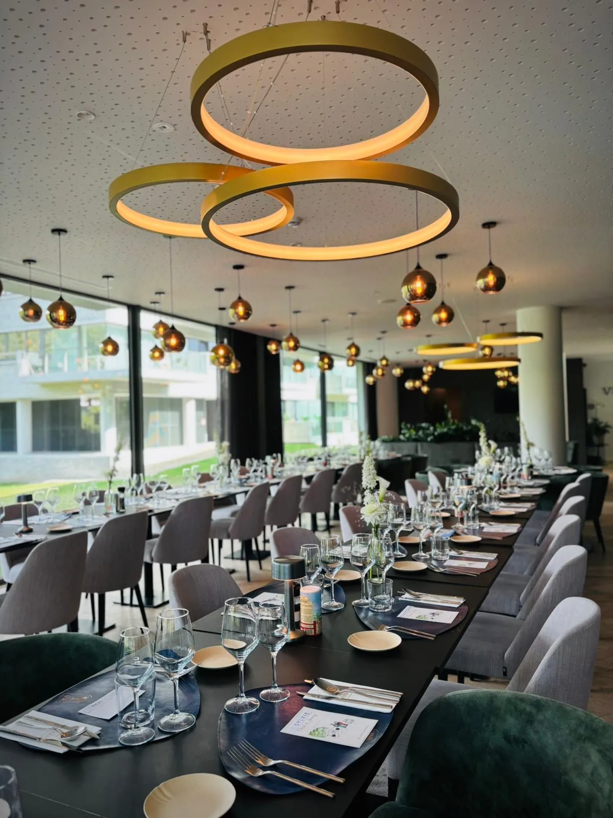 Een lange gedekte tafel onder de gouden lampen
