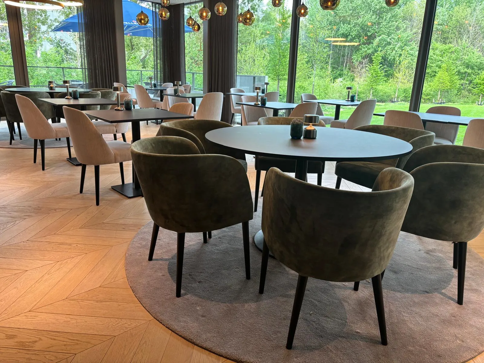 Het interieur van Bistro Babo met grote ramen op het park